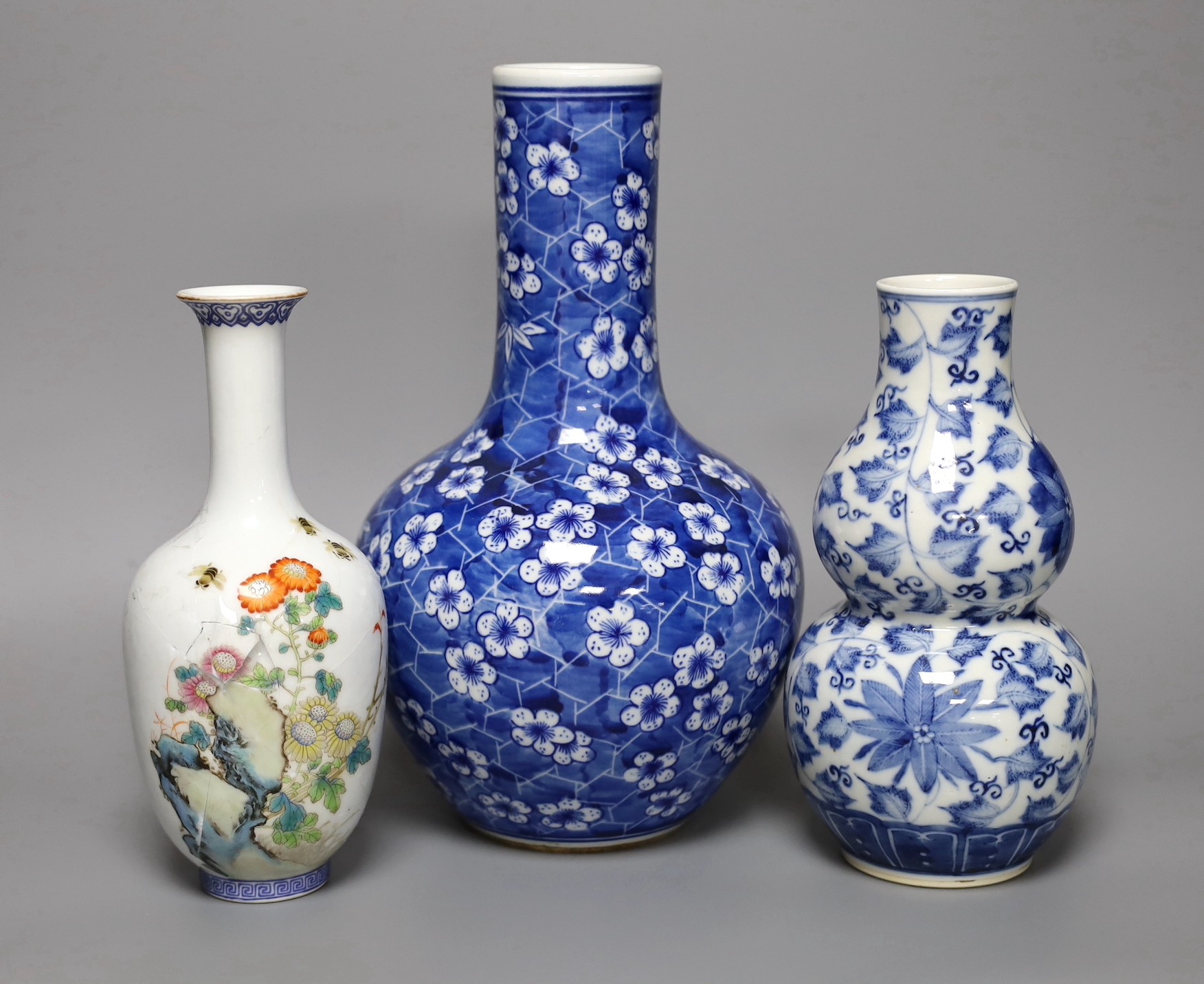 A Chinese blue and white bottle vase, a similar double gourd vase and a famille rose bottle vase a.f., tallest 26cm